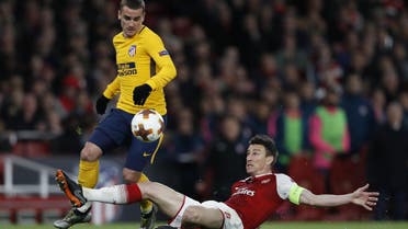 Atletico Madrid’s Antoine Griezmann (L) vies with Arsenal’s defender Laurent Koscielny on his way to scoring their first goal during the first leg semi-final football match at the Emirates Stadium in London on April 26, 2018. (AFP)