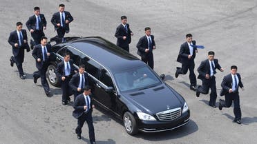 North Korean bodyguards jog next to a car carrying North Korea's leader Kim Jong Un returning to the North for a lunch break after a morning session of the inter-Korean summit at the truce village of Panmunjom on April 27, 2018. North Korean leader Kim Jong Un and the South's President Moon Jae-in sat down to a historic summit on April 27 after shaking hands over the Military Demarcation Line that divides their countries in a gesture laden with symbolism.