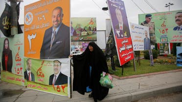 A woman walks past campaign posters of candidates ahead of parliamentary election, in Baghdad, Iraq April 22, 2018. REUTERS/Khalid al Mousily