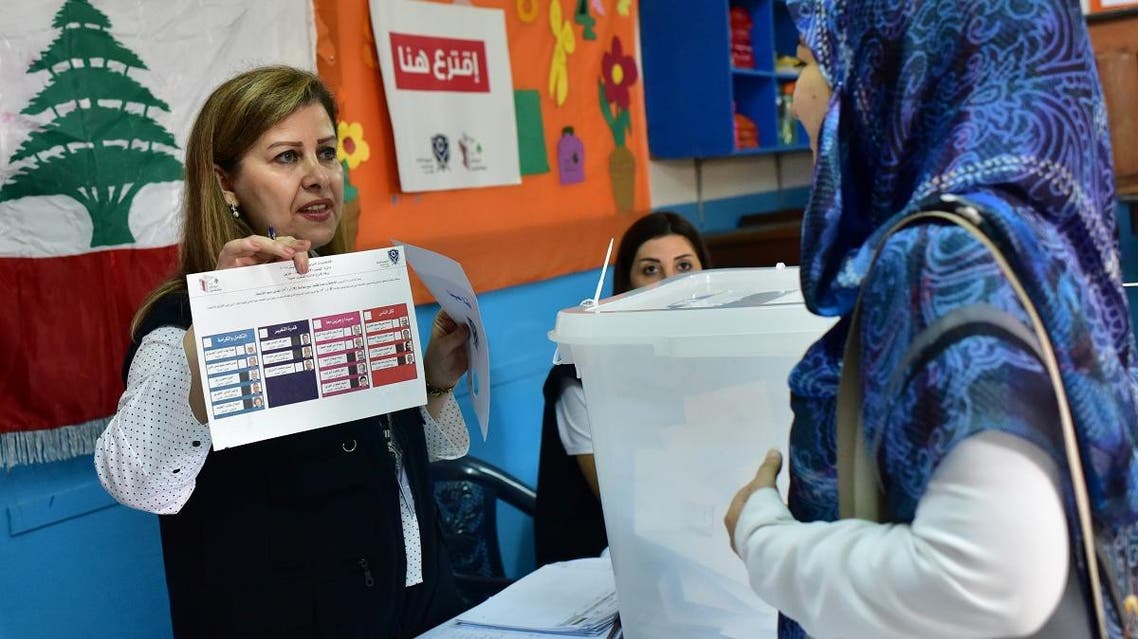 A polling station official explains the voting proceedure to a Lebanese national preparing to cast her ballot in the middle-eastern nations parliamentary election at a polling station set up at the Lebanese School in Abidjan. (AFP)