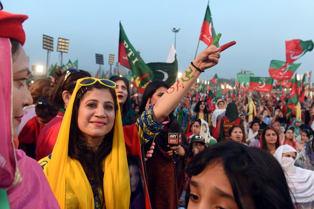 Supporters gesture and wave flags of the Pakistani political party Pakistan Tehreek-e-Insaf (PTI - Pakistan Movement for Justice) as they attend a rally with Pakistan opposition leader and leader of the party, in Lahore. (AFP)