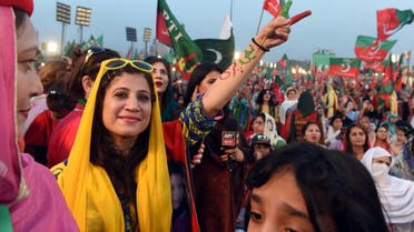 Supporters gesture and wave flags of the Pakistani political party Pakistan Tehreek-e-Insaf (PTI - Pakistan Movement for Justice) as they attend a rally with Pakistan opposition leader and leader of the party, in Lahore. (AFP)