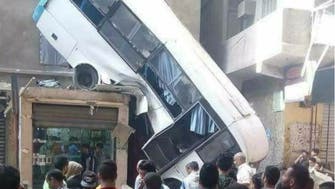 صور صادمة.. حافلة تسقط وتتعلق بركابها فوق منزل بمصر 