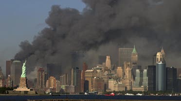 thick smoke billows into the sky from the area behind the Statue of Liberty, lower left, where the World Trade Center towers stood. (AP)