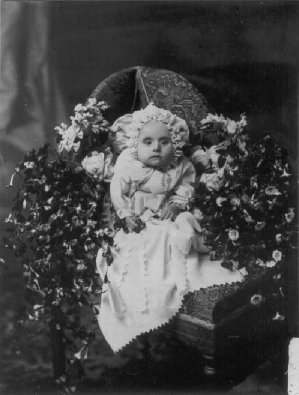 صورة لجثة طفل رضيع محاط بالزهور ضمن ما يعرف بتصوير الموتى
