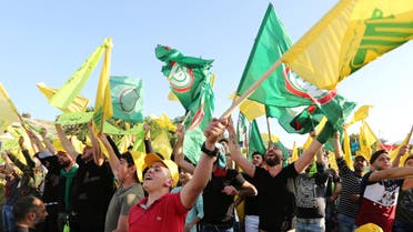 Supporters of Lebanon's Hezbollah chant slogans and hold flags as they listen to their leader Sayyed Hassan Nasrallah during a rally, in Mashghara village in the Bekaa Valley, Lebanon April 15, 2018. REUTERS/Aziz Taher