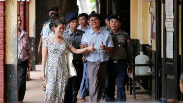 Detained Reuters journalist Wa Lone (C) escorted by police and his wife arrives for a court hearing in Yangon on April 25, 2018. (Reuters)