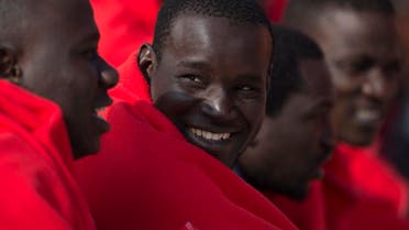 Migrants keep warm with Red Cross blankets upon their arrival at Malaga’s harbor on April 26, 2018, after an inflatable boat carrying 80 men, 6 women and 4 children was rescued by the Spanish coast guard off the Spanish coast. (AFP)