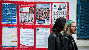 People walk past electoral posters in l'Ariana, outside Tunis, Friday, May 4 2018. (AP)