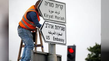 A worker hangs a road sign directing to the U.S. embassy, in the area of the U.S. consulate in Jerusalem, May 7, 2018. (Reuters)