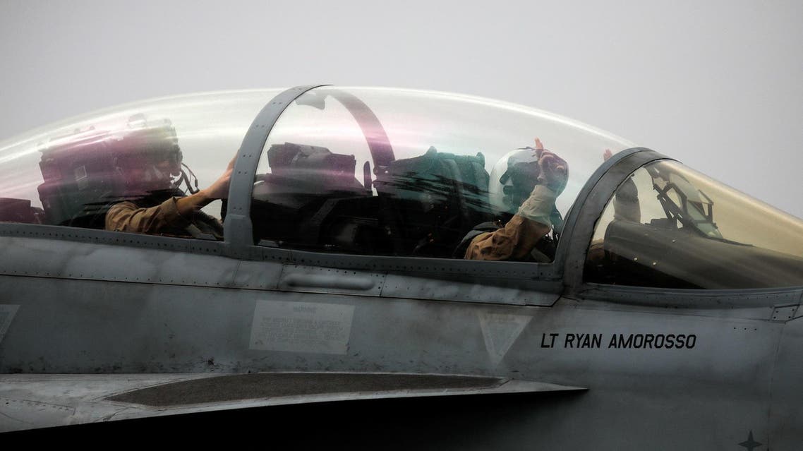 A Navy F/A-18 pilot gestures before taking off from the USS Harry S. Truman aircraft carrier. (Reuters)