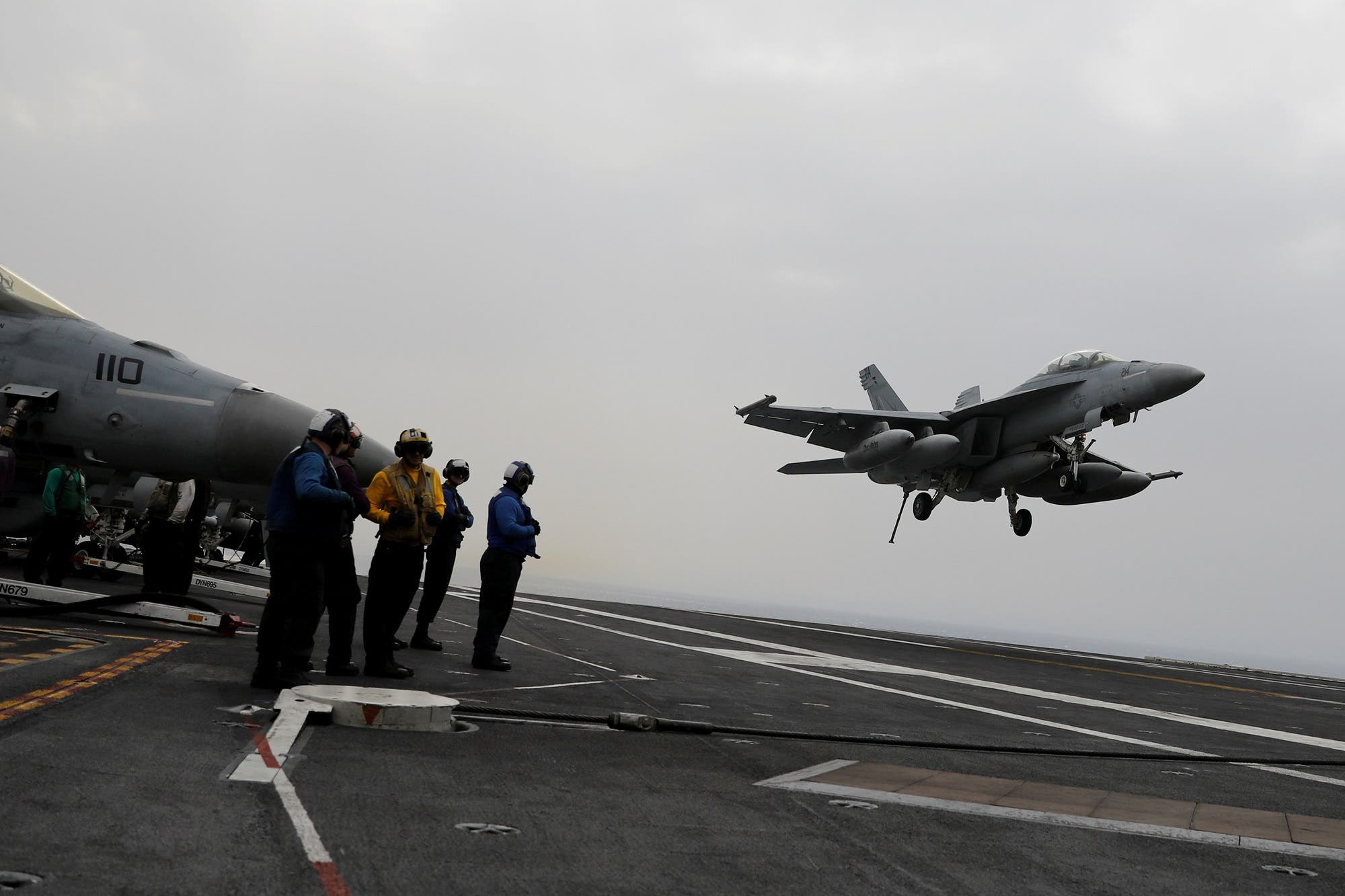 A Navy F/A-18 pilot gestures before taking off from the USS Harry S. Truman aircraft carrier. (Reuters)