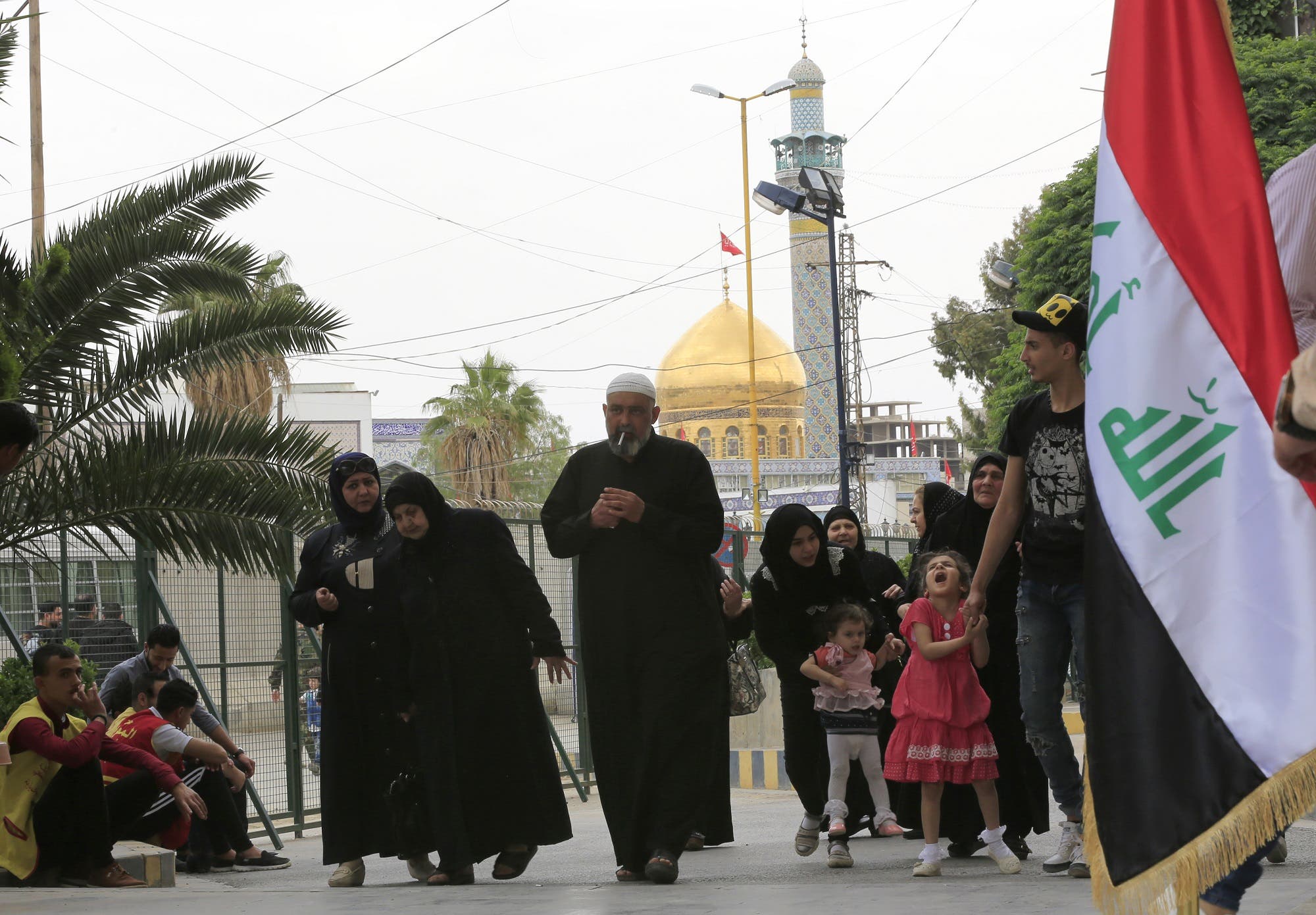 People walk in front of the Sayyida Zeinab mosque on the outskirts of the Syrian capital Damascus on May 10, 2018, as Iraqi residents of Syria vote for the Iraqi parliamentary elections. (AFP)
