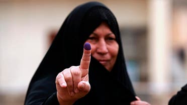 An Iraqi woman shows her ink-stained finger after casting her vote in the country's parliamentary elections in Ramadi. (AP)