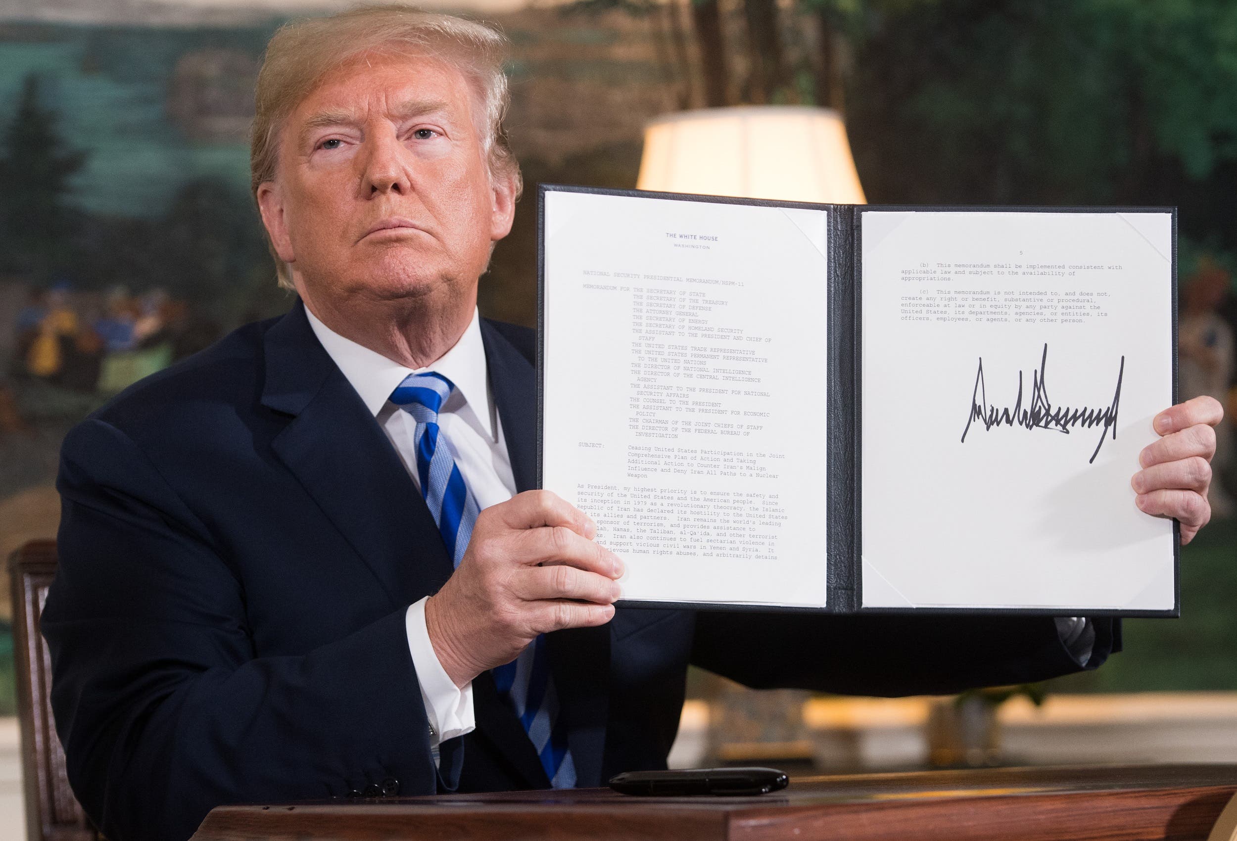 President Trump signs a document reinstating sanctions against Iran after announcing the US withdrawal from the Iran Nuclear deal at the White House. (File photo: AFP)