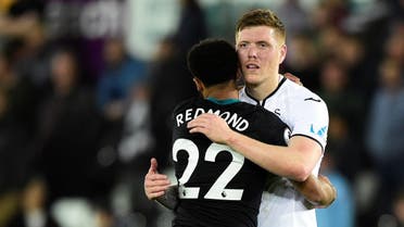 Swansea City's Alfie Mawson hugs Southampton's Nathan Redmond after the match. (Reuters)