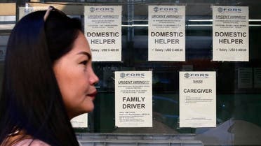 A woman passes help wanted signs outside a recruitment agency for jobs abroad in Manila. (AP)