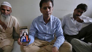 Abdul Aziz Sheikh, center, father of Sabika Sheikh, a victim of a shooting at a Texas high school, shows a picture of his daughter in Karachi, Pakistan, on May 19, 2018. (AP)