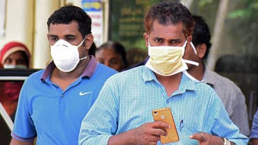 Indian residents wear face mask outside the Medical College hospital in Kozhikode on May 21, 2018. (AFP)