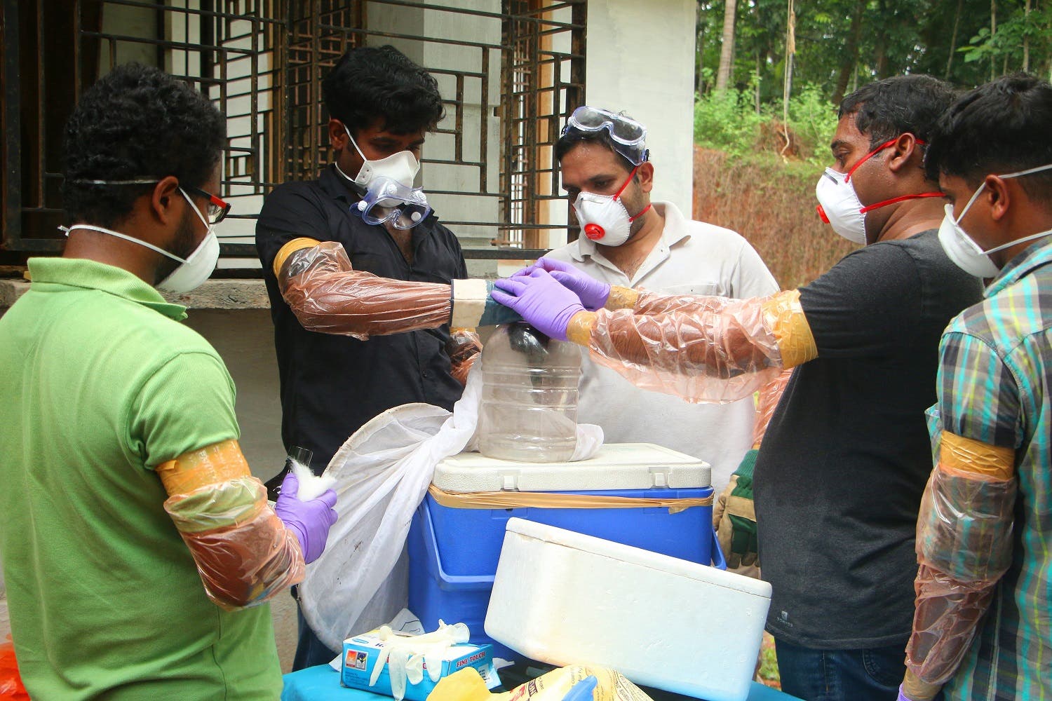 Animal Husbandry department and Forest officials deposit a bat into a container after catching it inside a well at Changaroth in Kozhikode, Kerala, on May 21, 2018. (AFP)