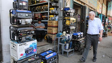 An Iraqi man shops at a store selling power generators in Baghdad on April 7, 2018. 