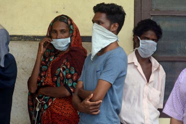 People in India stand outside a hospital wearing masks as a precautionary measure against the Nipah virus on May 21, 2018. (AP)