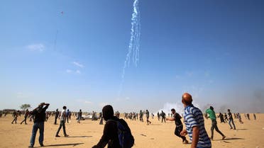 Palestinian protesters look up at falling tear gas cannisters dropped by an Israeli quadcopter drone during clashes near the border with Israel east of Khan Yunis in the southern Gaza Strip. (AFP) 