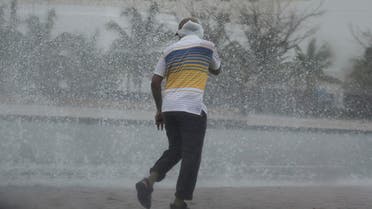 A man covers his head under the rain in Salalah, Oman, Friday, May 25, 2018. Cyclone Mekunu pounded the Yemeni island of Socotra in the Arabian Sea on Thursday morning, lashing it with heavy rain and strong winds as the powerful storm remained on a path to strike Oman this weekend. At least 17 people were reported missing. (AP Photo/Kamran Jebreili)