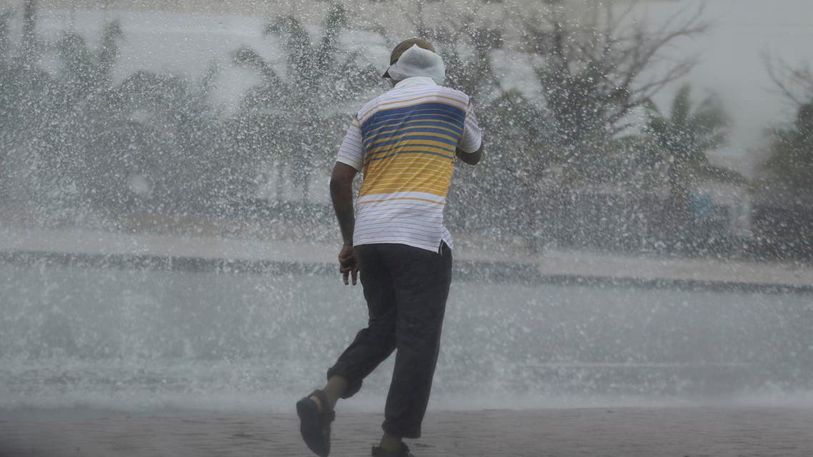 A man covers his head under the rain in Salalah, Oman, Friday, May 25, 2018. Cyclone Mekunu pounded the Yemeni island of Socotra in the Arabian Sea on Thursday morning, lashing it with heavy rain and strong winds as the powerful storm remained on a path to strike Oman this weekend. At least 17 people were reported missing. (AP Photo/Kamran Jebreili)