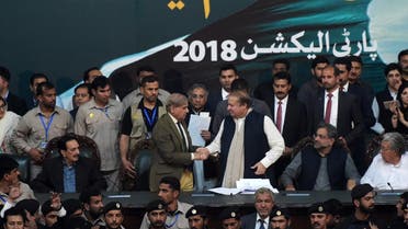 Pakistani Chief Minister of Punjab province Shahbaz Sharif, shakes hands with his brother and ousted prime minister Nawaz Sharif (3R) while Prime Minister of Pakistan Shahid Khaqan Abbasi (2R) looks on, after being elected President of ruling Pakistan Muslim League-Nawaz (PML-N) party at the General Workers Council in Islamabad on March 13, 2018. (AFP)