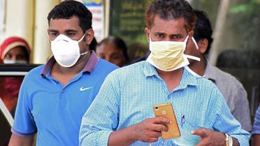 Indian residents wear face mask outside the Medical College hospital in Kozhikode on May 21, 2018. (AFP)