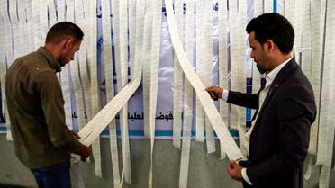 Iraqi electoral commission employees examine electronic counting machine print-outs in the central holy city of Najaf. (AFP)