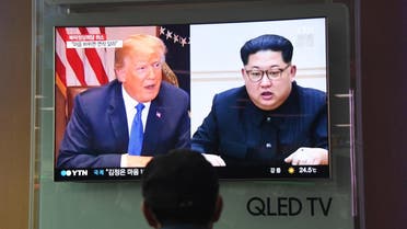 A man watches a television news screen showing US President Donald Trump (L) and North Korean leader Kim Jong Un (R). (AFP)
