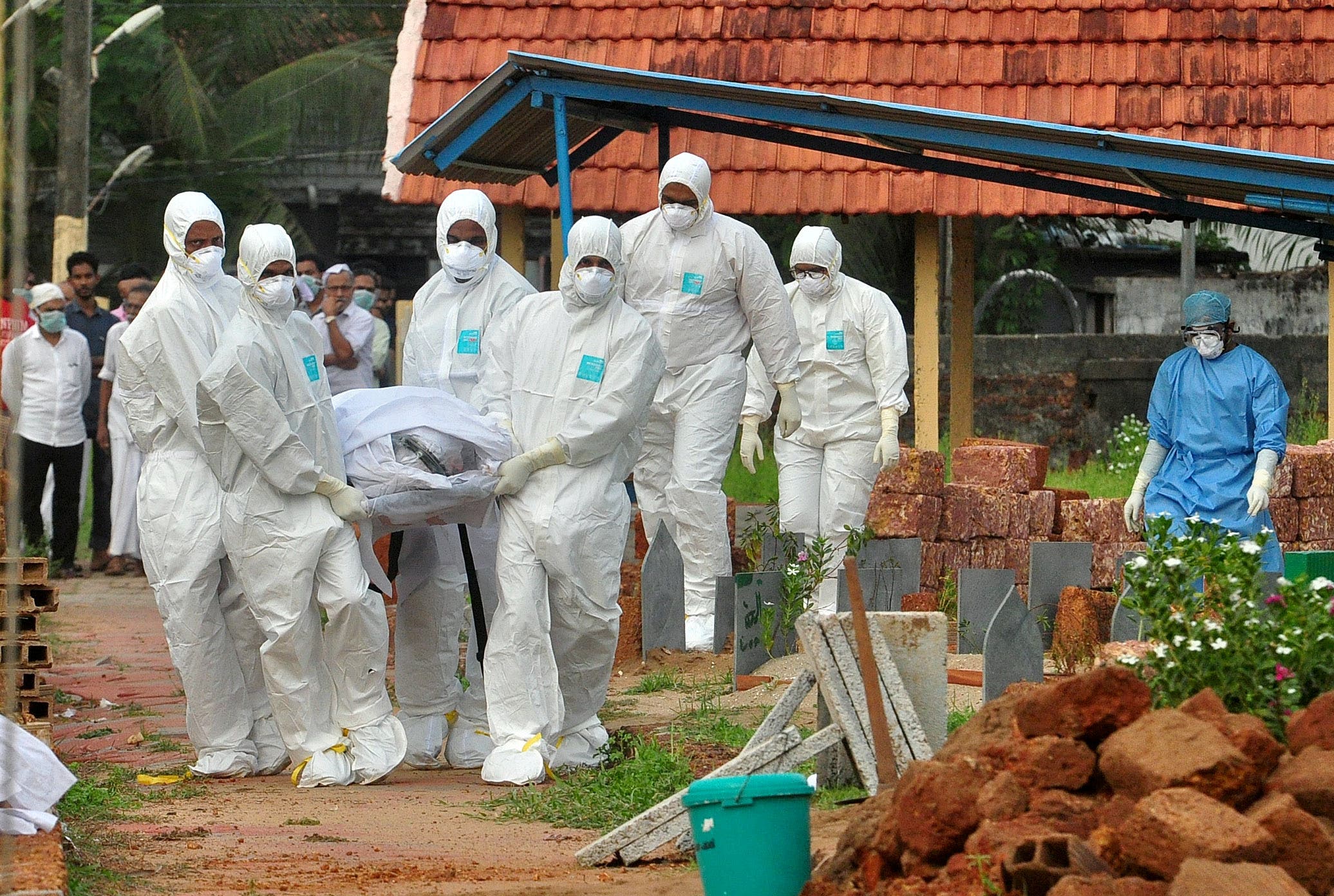 Doctors and relatives wearing protective gear carry the body of a victim, who lost his battle against the brain-damaging Nipah virus, during his funeral at a burial ground in Kozhikode, in the southern Indian state of Kerala, India. (File photo: Reuters)