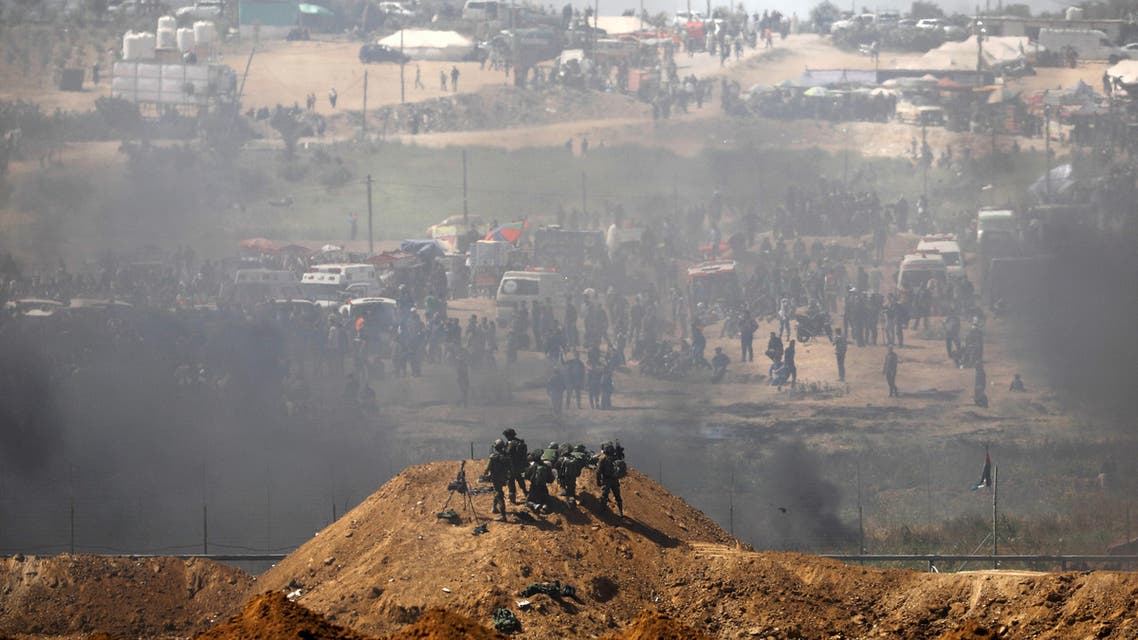Gaza Border, Israel Israeli soldiers are seen next to the border fence on the Israeli side of the Israel-Gaza border as Palestinians protest on the Gaza side of the border April 6, 2018. (Reuters)