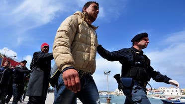 Policemen escort Tunisians would-be immigrants who are waiting to be identified on the Italian island of Lampedusa. (AFP)