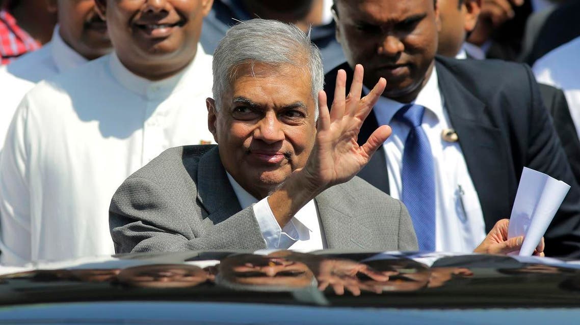 Sri Lankan Prime Minister Ranil Wickremesinghe waves to media as he leaves after appearing before a presidential commission of inquiry into issuance of treasury bonds in Colombo. (AP)