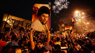Supporters of Muqtada al-Sadr carry his image as they celebrate in Tahrir Square, Baghdad, on May 14, 2018. (AP)