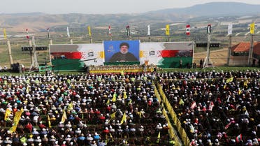 Hassan Nasrallah addresses his supporters via a screen during a rally near the border with Israel on June 8, 2018. (Reuters)