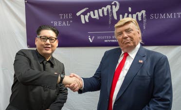 Kim Jong Un and Donald Trump impersonators Howard X (L) and Dennis Alan (R) shakes hands during a promotional event on June 9, 2018 in Singapore. (AFP)