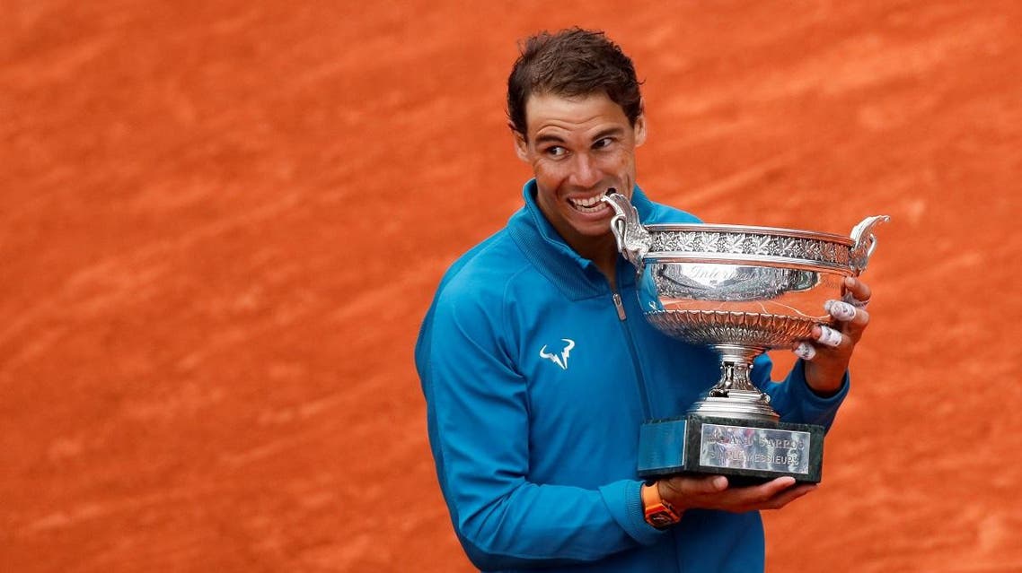Rafael Nadal celebrates by biting the trophy after winning the final against Austria's Dominic Thiem. (Reuters)