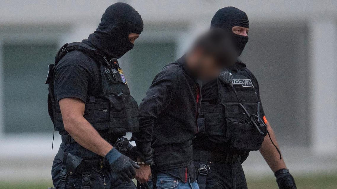 Police officers of a special unit escort Iraqi asylum seeker Ali Bashar, who is suspected of having killed a German teenage girl, from a helicopter to the police headquarters in Wiesbaden, western Germany, after he was flown back from Erbil to Germany on June 9, 2018. (AFP)
