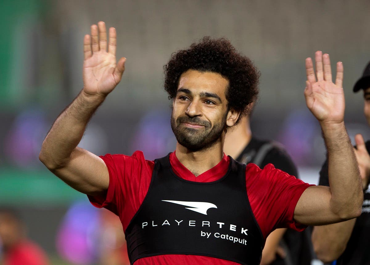 Egyptian national team soccer player and Liverpool's star striker Mohammed Salah smiles as he greets fans during the final training of the national team at Cairo Stadium in Cairo. (AP)