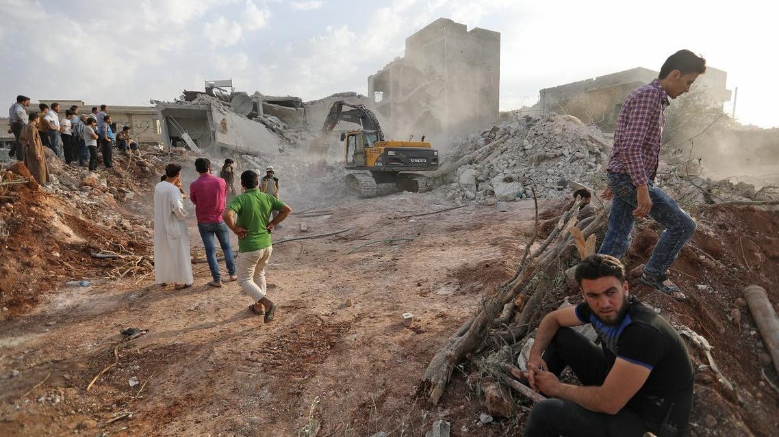 Syrians gather amid destruction in Zardana, in the northern Syrian Idlib province, in the aftermath of air strikes late on June 8. (AFP)