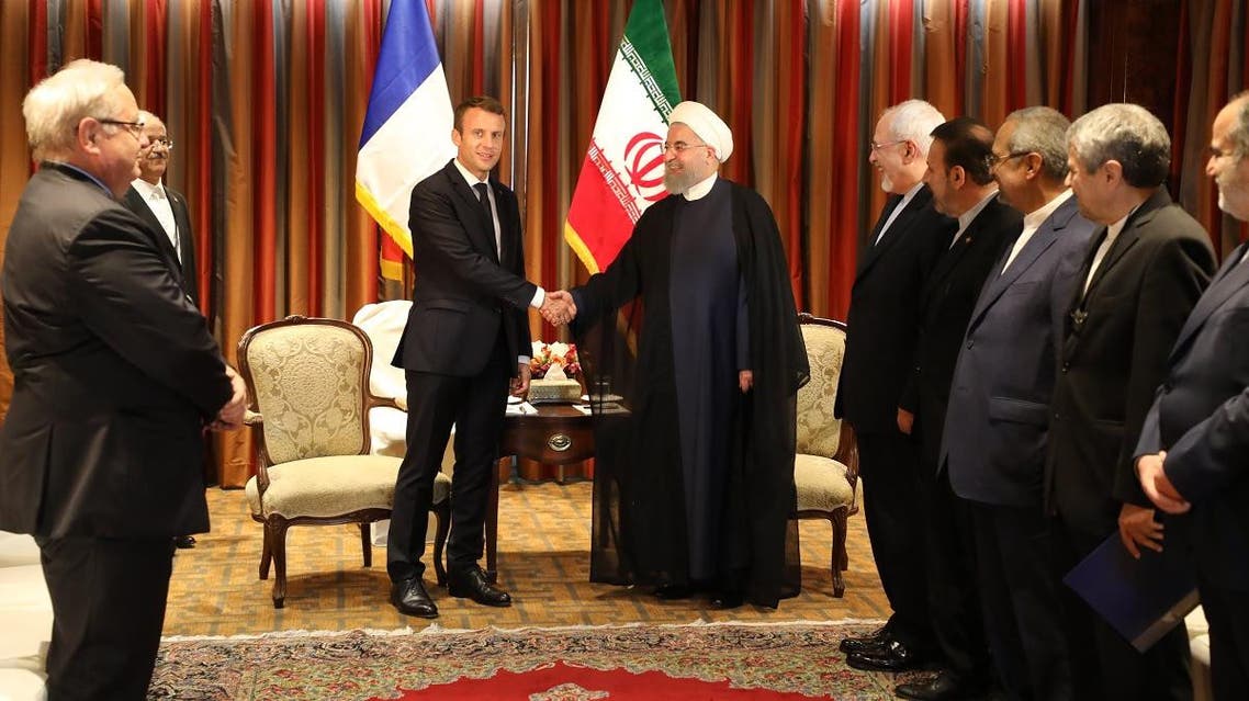Macron (C-L) shakes hands with his Iranian counterpart Hassan Rouhani as Iran's foreign minister, Mohammad Javad Zarif (5th R) and other members of the Iranian delegation (R) stand next to them during an official meeting. (AFP)