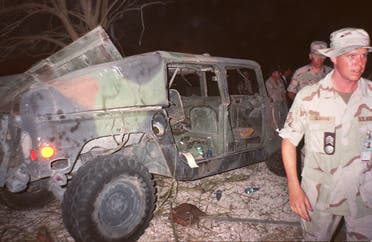 US soldiers pass by a destroyed military truck on June 26, 1996 near the site of the truck bomb which exploded on June 25, 1996 outside a military personnel housing complex in Khobar near Dhahran. (AFP)