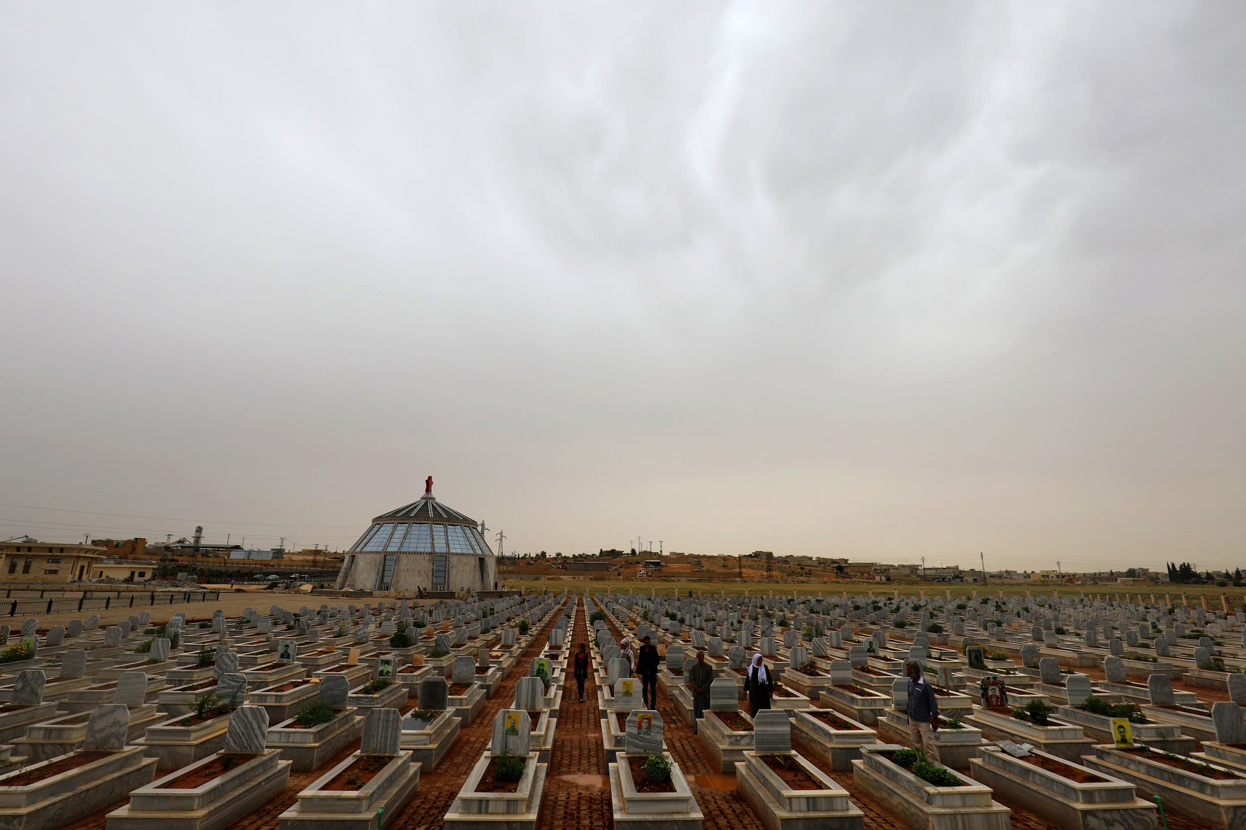 Syrian Kurds visit on May 28, 2018 the tombs of loved ones at a cemetery in Kobane. (AFP)