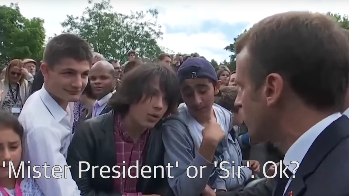 The young man, who looked to be in his mid-teens, was standing behind a barrier as Macron passed along the crowd. (Screengrab)