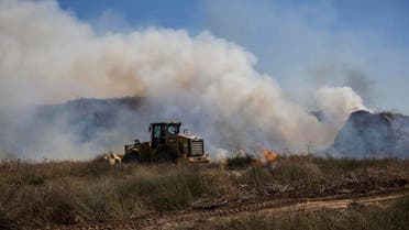 An Israeli tractor extinguishes a fire started by a kite with attached burning cloth launched by Palestinians from Gaza, on the Israel and Gaza border, on June 20, 2018. (AP)