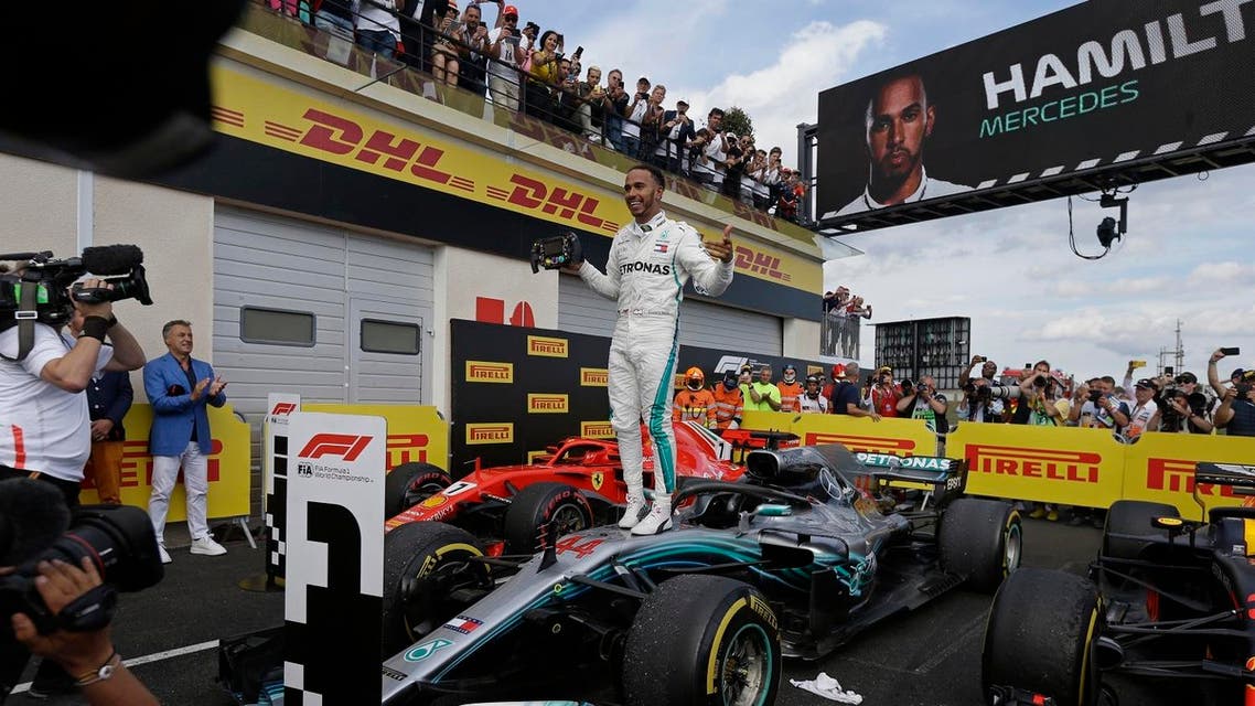 Mercedes driver Lewis Hamilton of Britain celebrates while standing on his car after winning the French Formula One Grand Prix (AP)